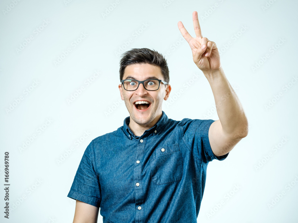 Fototapeta premium Happy man showing victory gesture
