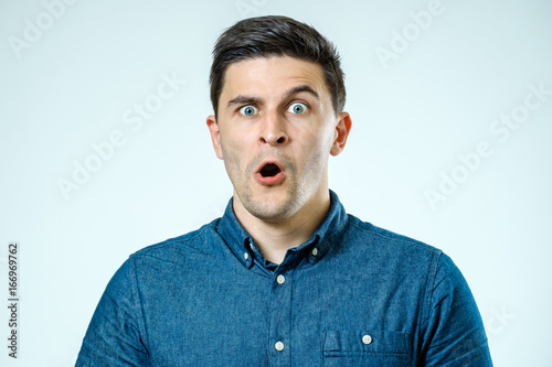 Tableau sur toile Portrait of young surprised man with opened mouth