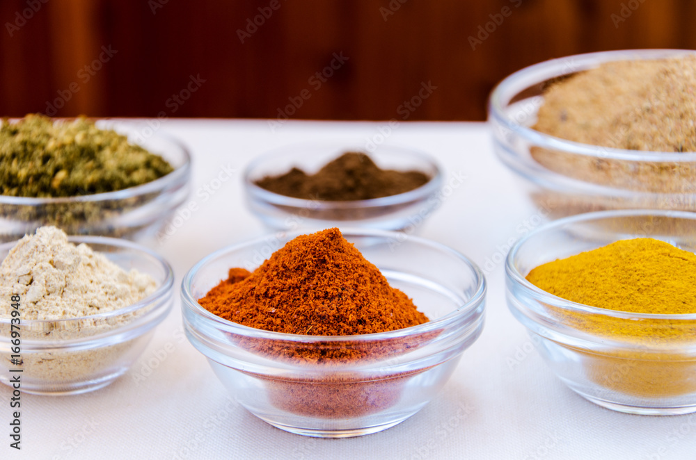 Different kind of colorful spices powder in glass bowls. Food and cuisine additives.
