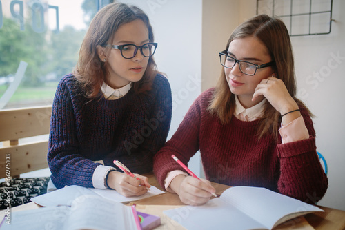 Two girls study in spare time, they solve mathematical and geometric exercises