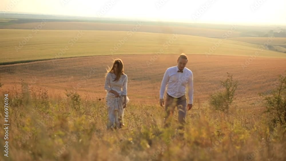 Happy couple hugging in a meadow. Happy couple having fun outdoors.