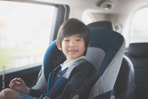 Portrait of cute Asian child sitting in car seat © lalalululala