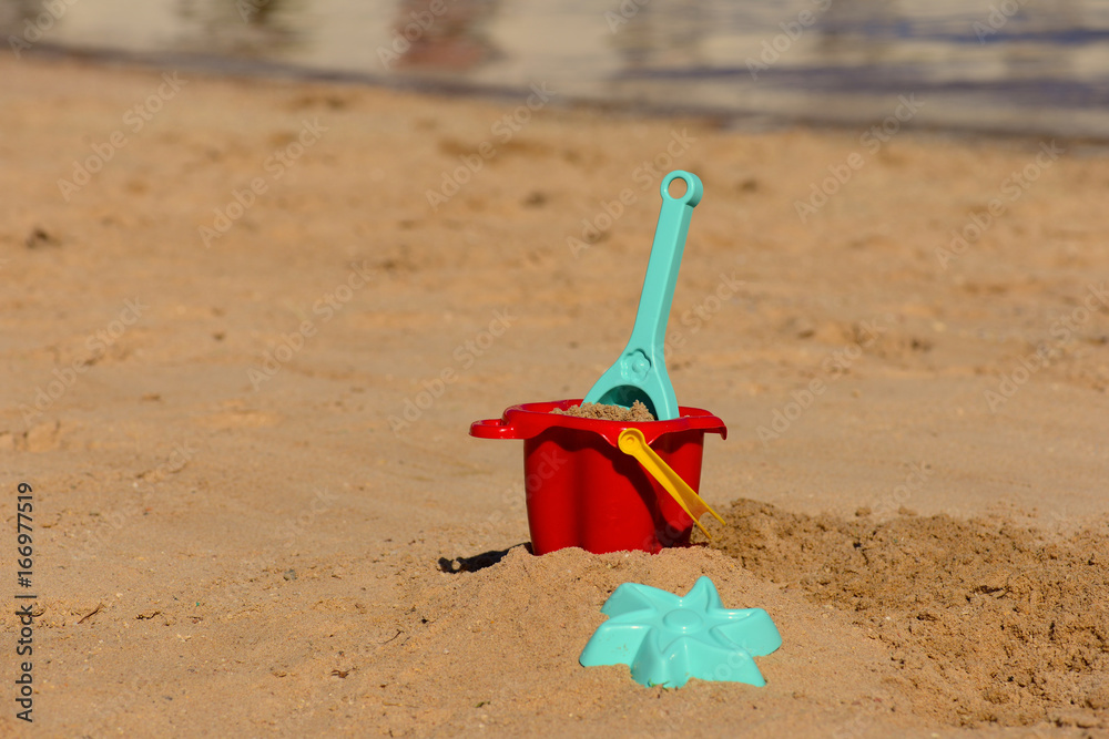 Colorful Summer Children's beach toys on a sandy beach by the sea Colorful Summer Children's beach toys on a sandy beach by the sea