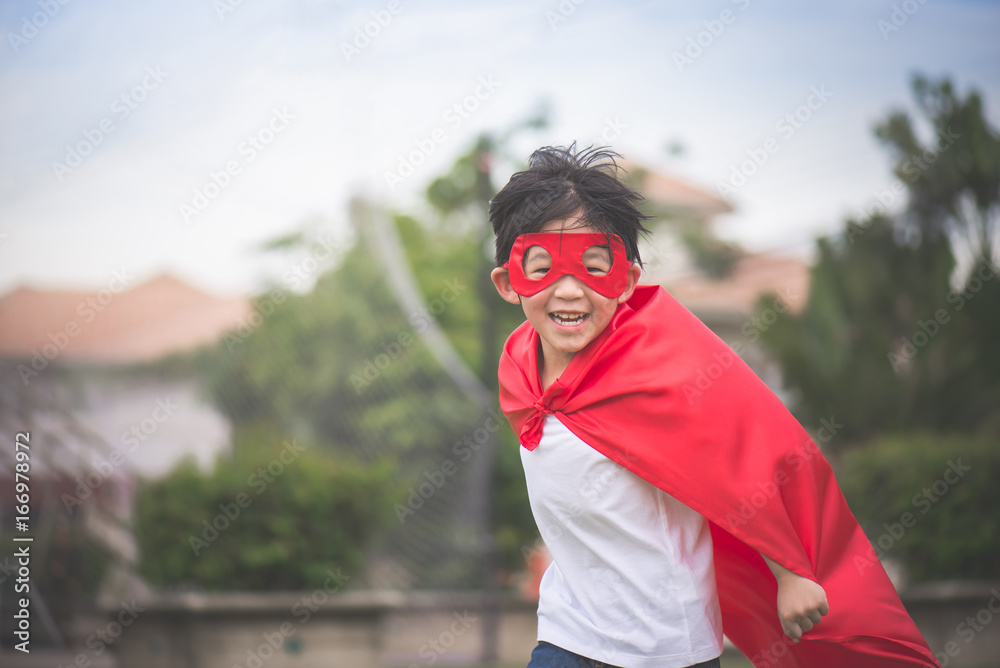 Asian child in in Superhero's costume playing in the park