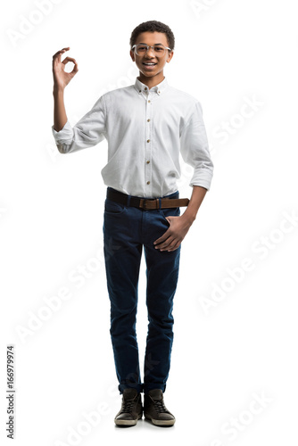 smiling african american teenager showing ok sign isolated on white