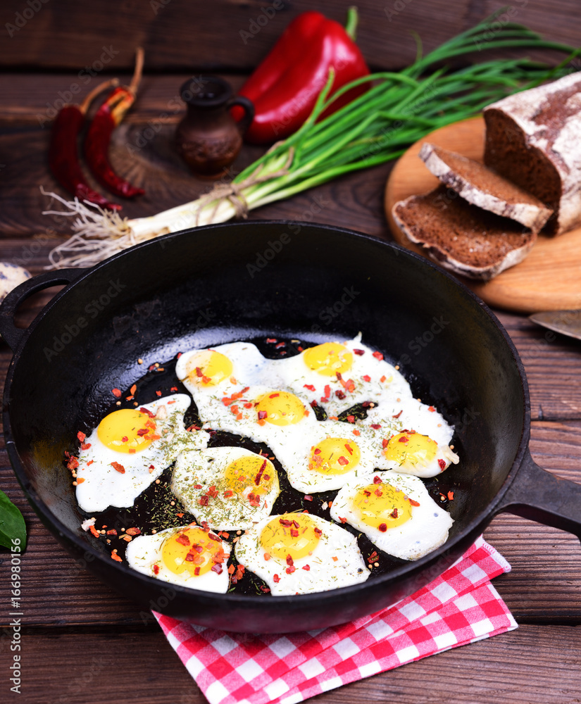 Fried eggs in a black cast-iron frying pan Fried eggs in a black cast-iron frying pan