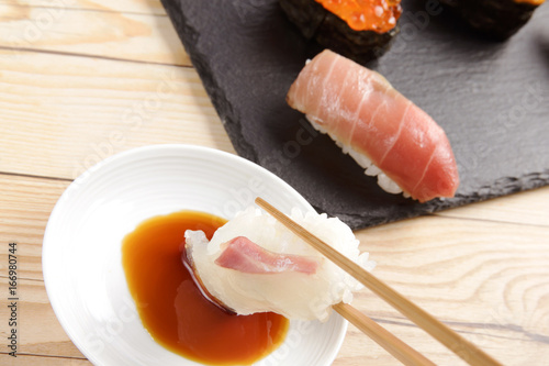 Sea bream sushi dipping in soy sauce