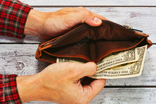 Wallpaper Mural Man in work shirt holding wallet with just two dollars Torontodigital.ca