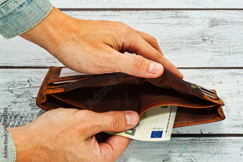 Wallpaper Mural Man holding in hands almost empty wallet Torontodigital.ca