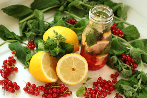 Drink of mint, lemon and red currant in bottle of glass with straw. between in Ingredients
