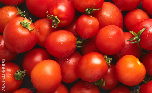 A top view  aerial view of a tray of bright red ripe tomatoes.