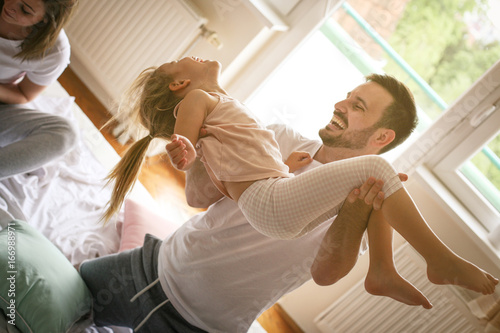 Happy family having fun on bed.