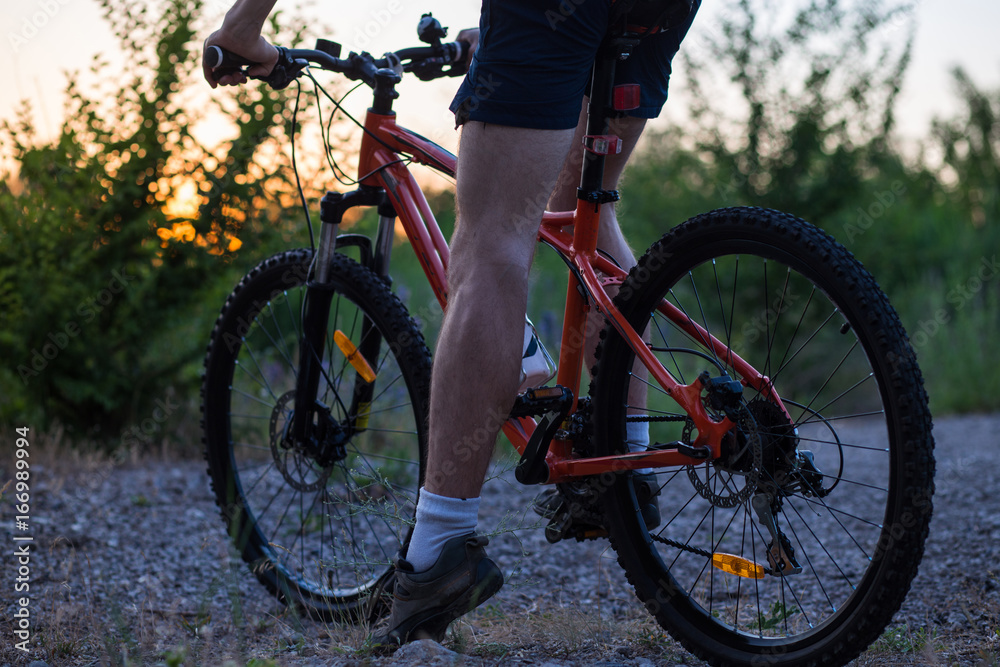 Young sporty man riding a bicycle at sunset. Silhouette of a bicyclist Young sporty man riding a bicycle at sunset. Silhouette of a bicyclist