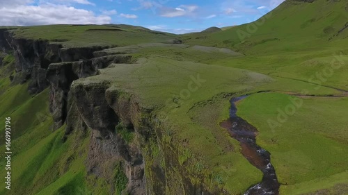 View of the valley with a river and a cliff with a waterfall. Andreev. photo