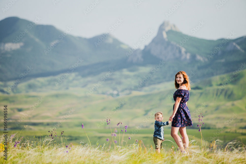 A woman with a little boy in the background of the mountains