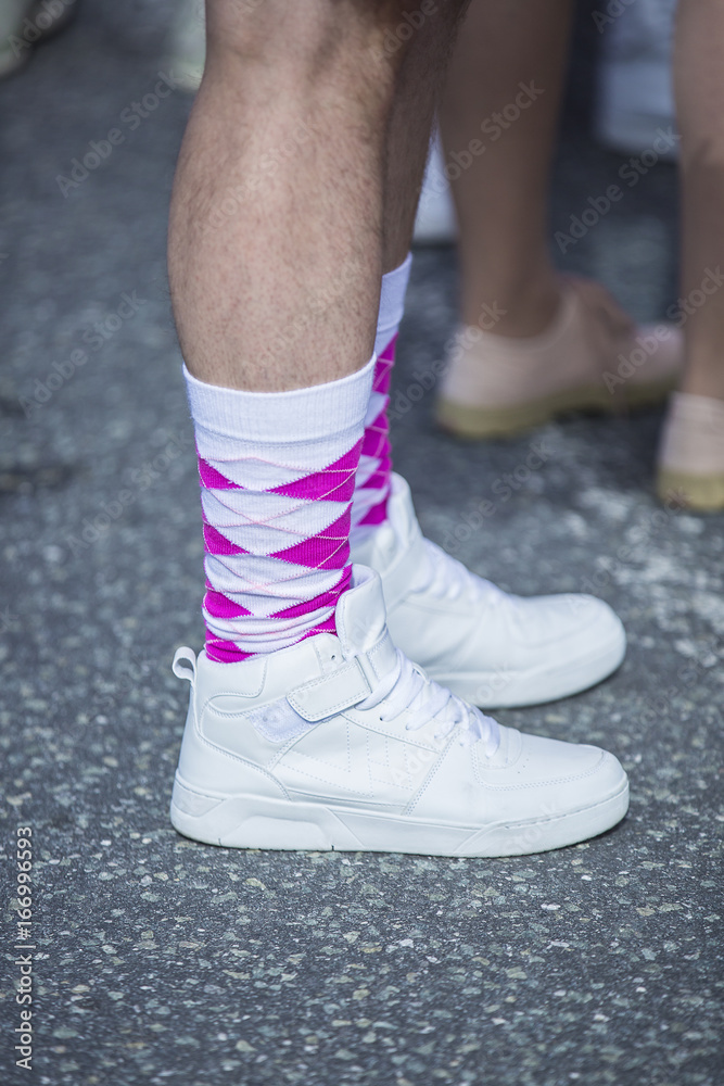 close un on men feet with white runners and white and pink socks