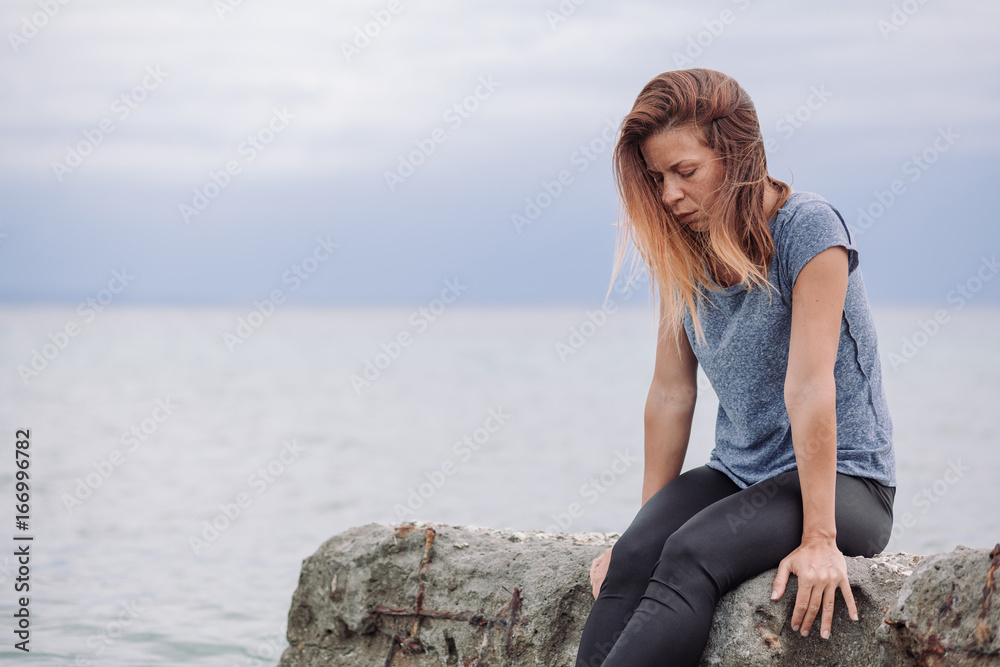 Woman alone and depressed at seaside