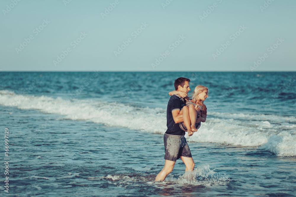 Young couple in love walking on the beach Young couple in love walking on the beach