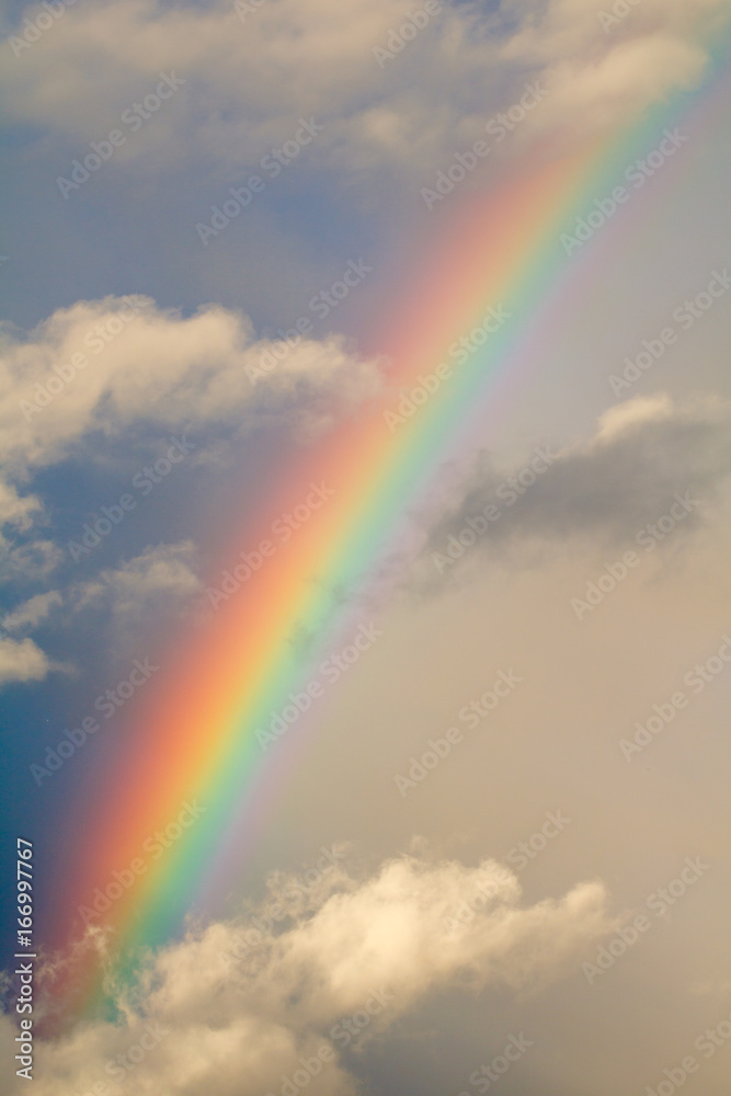 Beautiful rainbow after rain in the blue cloudy sky Beautiful rainbow after rain in the blue cloudy sky