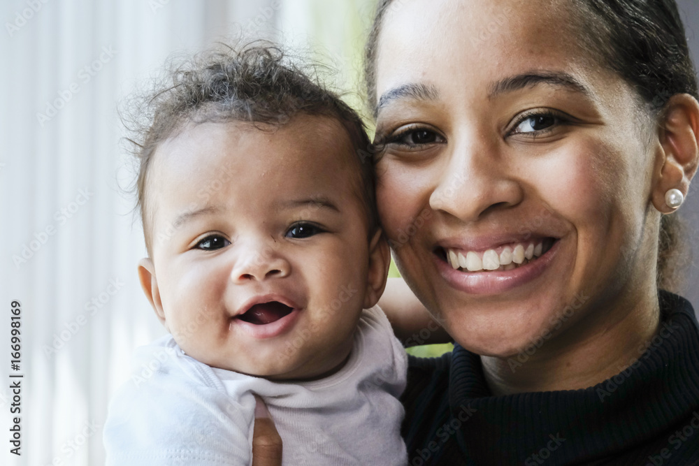 Close up portrait of a African American woman holding a baby girl Close up portrait of a African American woman holding a baby girl