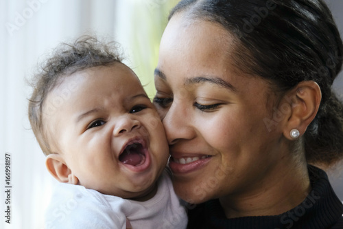 Close up portrait of a African American woman holding a baby girl photo