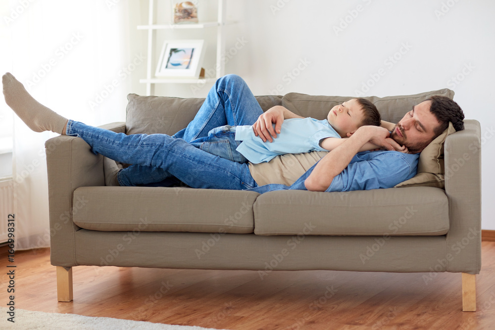happy father and son sleeping on sofa at home