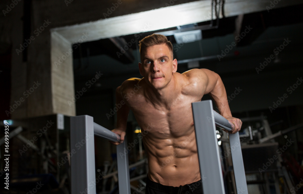 man doing triceps dip on parallel bars in gym man doing triceps dip on parallel bars in gym