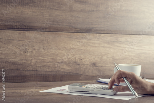 Canvas Print Side view of accountant balancing the books with calculator