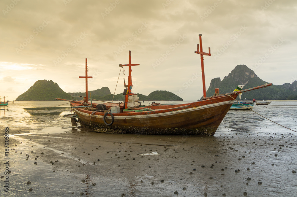 fishing boat on the beach with sea and sunrise background