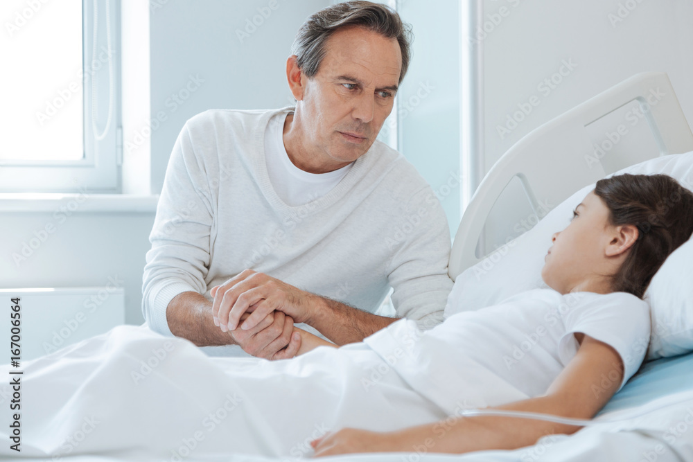 Obraz premium Serious unhappy man holding his daughters hand