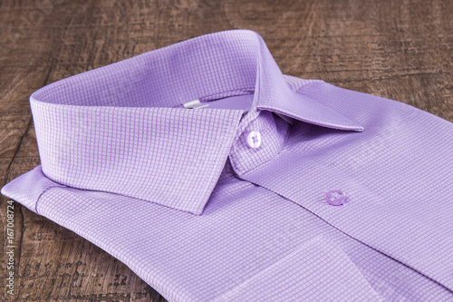 Lilac man's shirt on a wooden table.