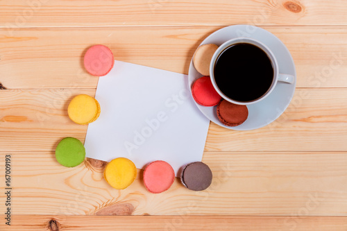 Blank card and coffee cup with space for your text on wooden background. Top view