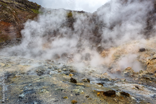 Steaming hot springs in Iceland on the background of colorful mountains