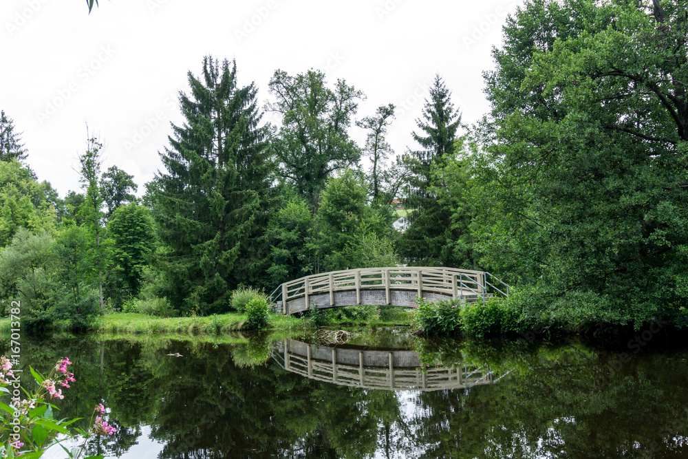 Über Wasser führende Holzbrücke mit Spiegelung Über Wasser führende Holzbrücke mit Spiegelung