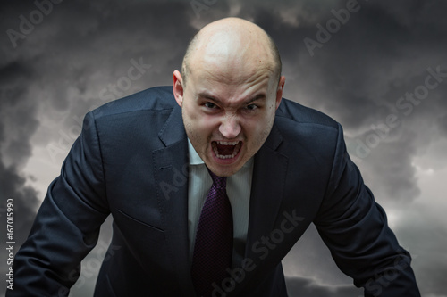 Angry boss. Businessman in suit with very angry face screaming. photo