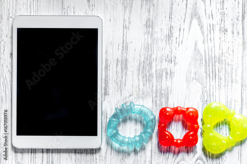 Mockup for adoption concept. Tablet PC near toy on light wooden background top view copyspace photo