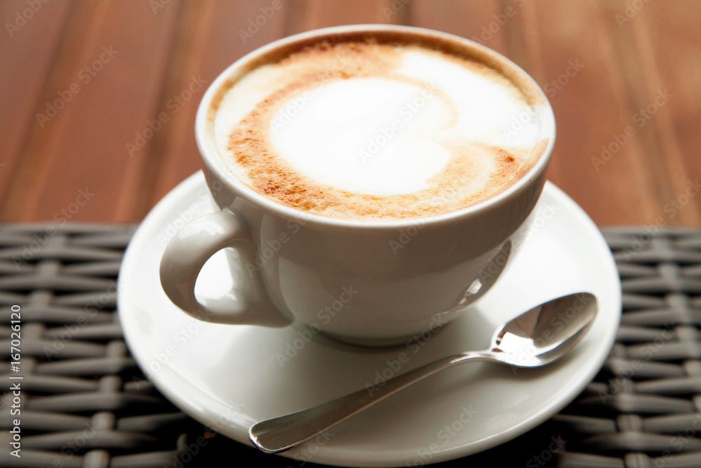 Close up cup ofcapuccino latte art heart coffee on wood backgrou