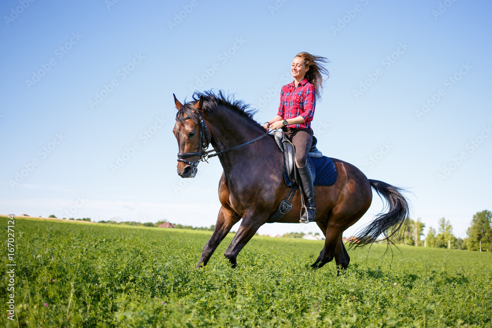 Happy young woman galloping horseback on field and enjoying feeling of freedom Happy young woman galloping horseback on field and enjoying feeling of freedom