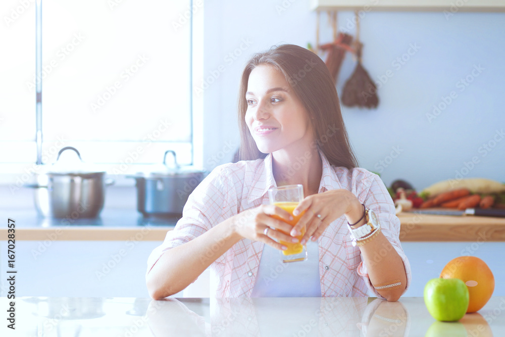 Young woman sitting a table in the kitchen Young woman sitting a table in the kitchen