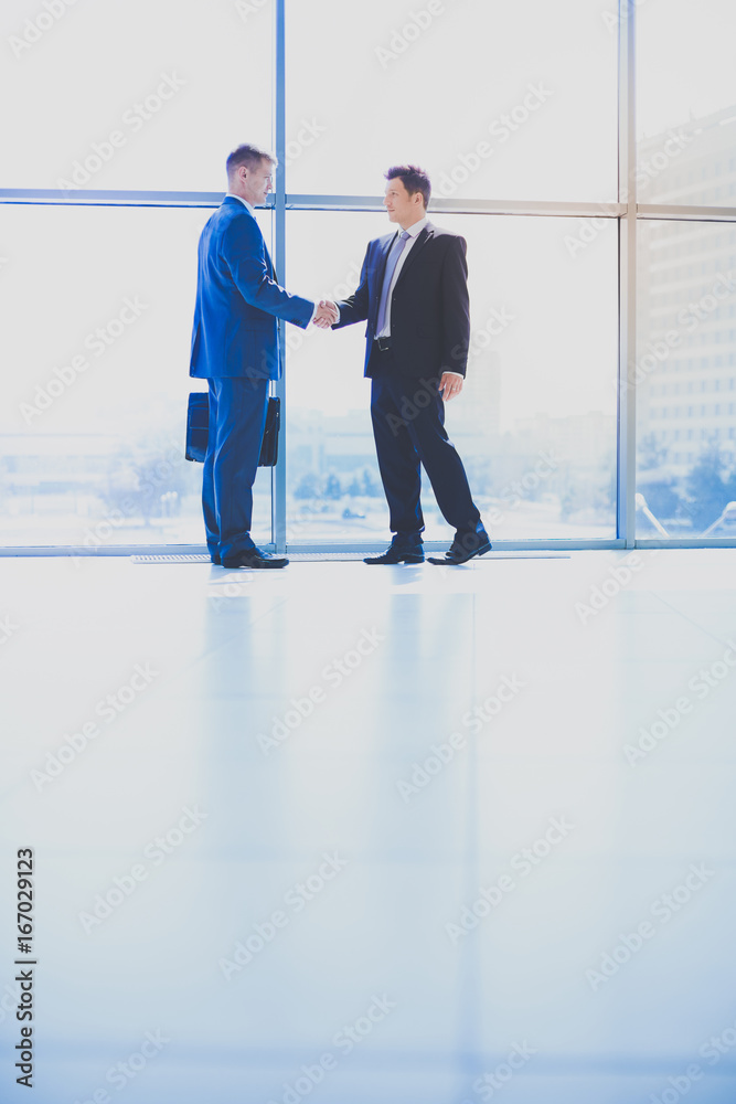 Image of two successful business men shaking hands with each other Image of two successful business men shaking hands with each other