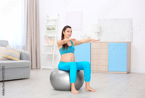 Young pregnant woman training at home. Health concept