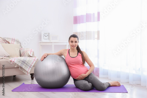 Young pregnant woman traini...