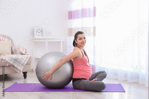 Young pregnant woman traini...