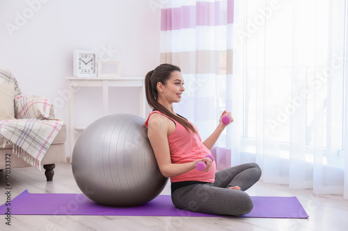 Young pregnant woman traini...