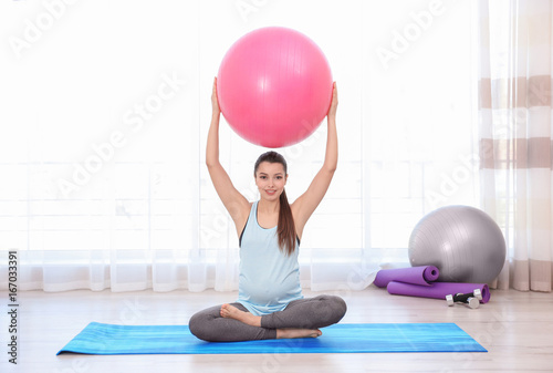 Young pregnant woman traini...