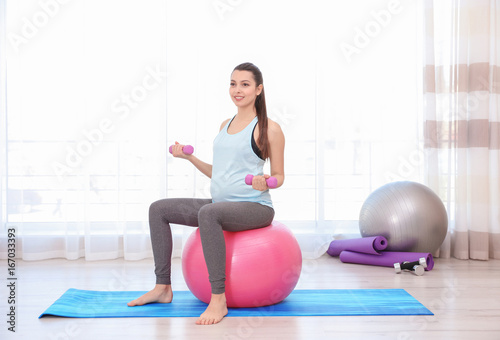 Young pregnant woman traini...