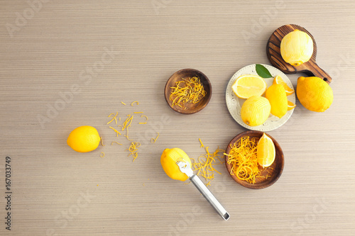 Composition with fresh lemons and zest on wooden table