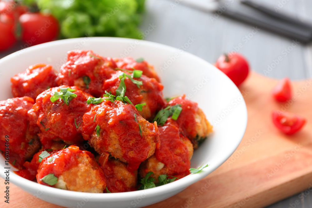 Bowl with delicious turkey meatballs and tomato sauce on table Bowl with delicious turkey meatballs and tomato sauce on table