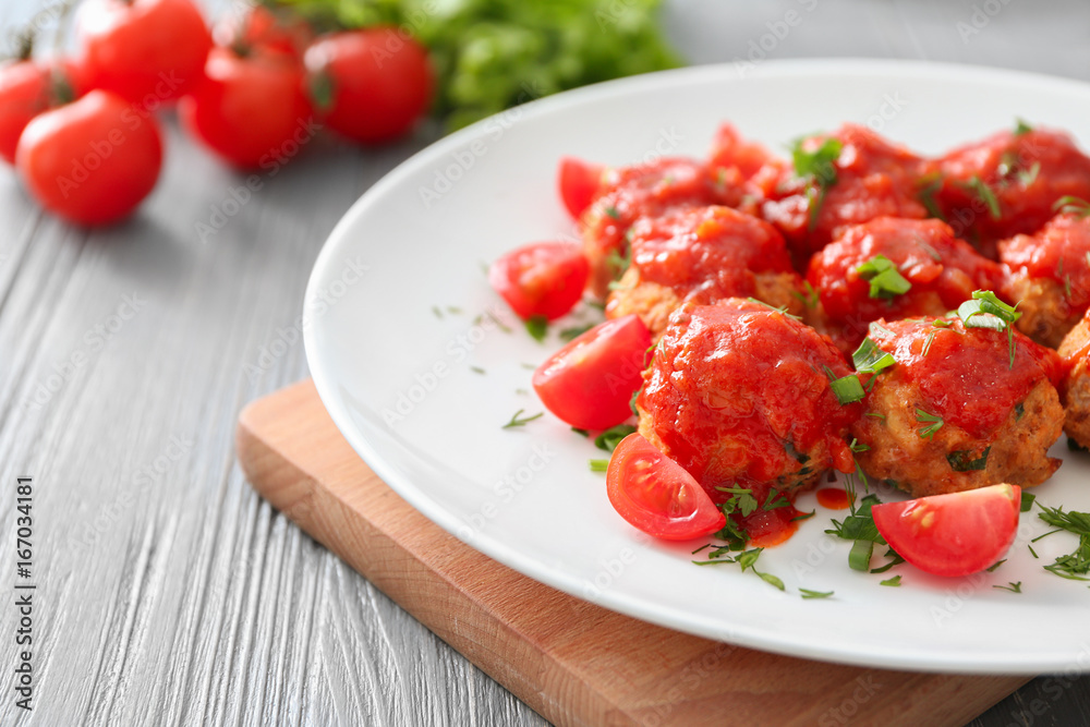 Plate with delicious turkey meatballs and tomato sauce on table, closeup
