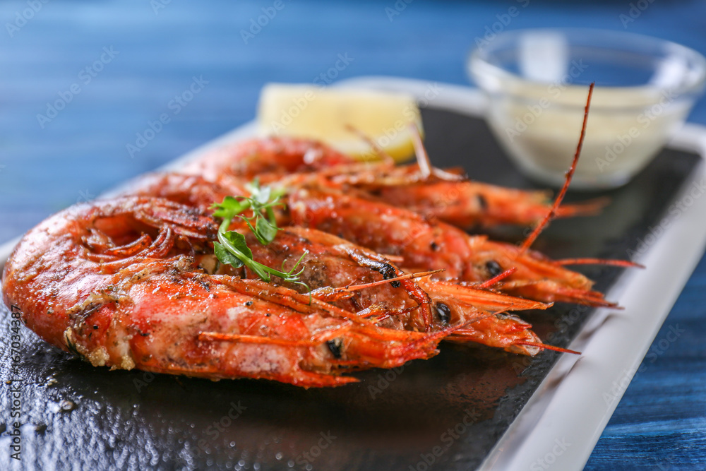 Slate plate with delicious shrimps on table Slate plate with delicious shrimps on table